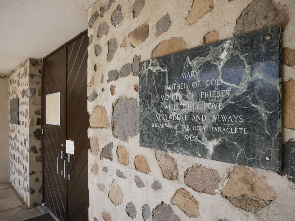 A Servants of the Paraclete plaque from 1962 is posted outside the door of Mary, Mother of Priests Catholic Church in Jemez Springs. Matt Dahlseid / The New Mexican