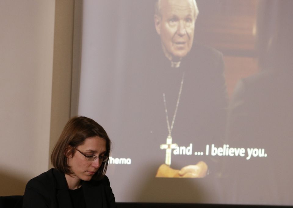 Doris Reisinger, an abuse survivor and former nun, is pictured as a video of her talking with Cardinal Christoph Schonborn of Vienna plays in the background during a news conference in Rome Feb. 19, 2019. (CNS/Paul Haring)