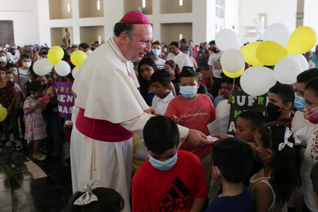Archbishop Franco Coppola, the apostolic nuncio to Mexico, gives a rosary to a child during a visit to Aguililla April 23, 2021. (CNS photo / Alan Ortega, Reuters)