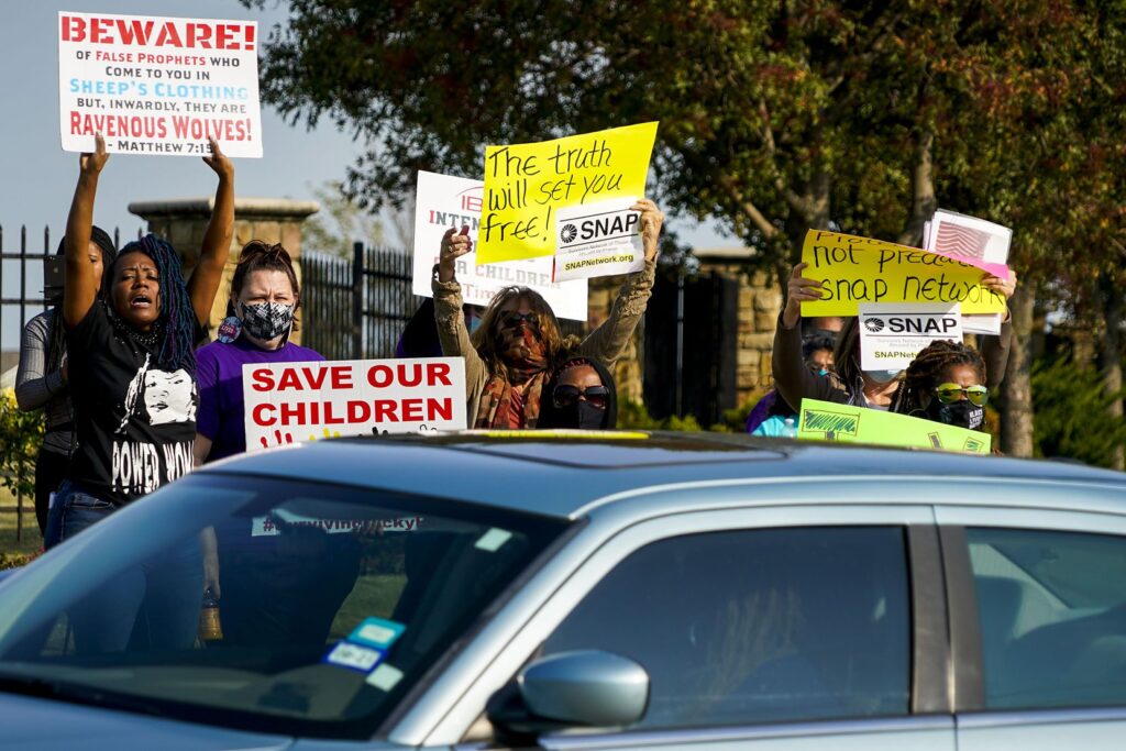 Demonstrators, including Donna Fields (left), yelled toward motorists entering the parking lot at Inspiring Body of Christ Church before services last Oct. 4.(Smiley N. Pool / The Dallas Morning News)