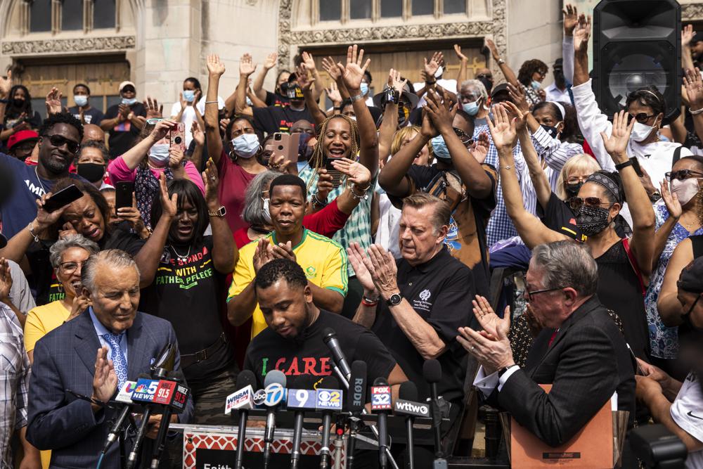 Father Michael Pfleger stands among supporters before a news conference outside St. Sabina Church, after the Archdiocese of Chicago announced that Pfleger will return to his role at senior pastor at at the Auburn Gresham church, Monday afternoon, May 24, 2021. The archdiocese cleared him to return after an internal probe into decades-old allegations of sexual abuse against minors. (Ashlee Rezin Garcia/Chicago Sun-Times via AP)