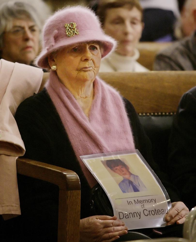 FILE — A woman holds a photo of Danny Croteau in this Tuesday, Feb. 26, 2008 file photo as she listens to testimony at the Statehouse, in Boston, on a number of sex offender bills during a hearing before the state's Legislature's Judiciary Committee. Investigators were preparing to seek an arrest warrant for a defrocked Roman Catholic priest long considered a suspect in the 1972 killing of a western Massachusetts altar boy shortly before his death last week, a prosecutor said Monday, May 24, 2021. (AP Photo/Stephan Savoia, File)