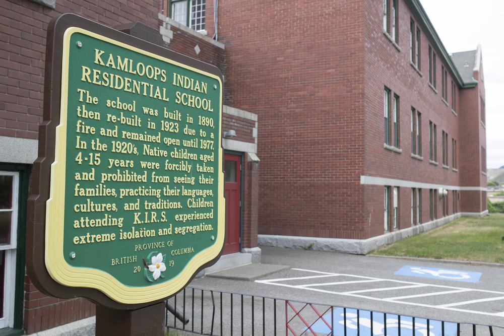 A plaque is seen outside of the former Kamloops Indian Residential School on Tk'emlups te Secwépemc First Nation in Kamloops, British Columbia, Canada on Thursday, May 27, 2021. The remains of 215 children have been found buried on the site of the former residential school in Kamloops. (Andrew Snucins/The Canadian Press via AP)