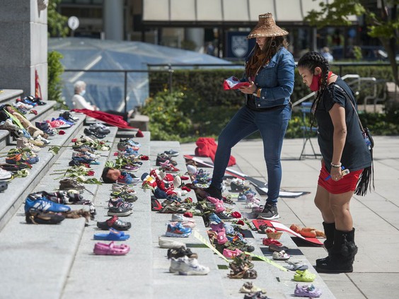 Two hundred and fifteen pairs of kids shoes line the steps of the Vancouver Art Gallery on Friday in response to the revelation that 215 children's remains were discovered this week at the site of the former Kamloops residential school. The shoes were placed on the steps by First Nations advocates from the Downtown Eastside. PHOTO BY JASON PAYNE /PNG