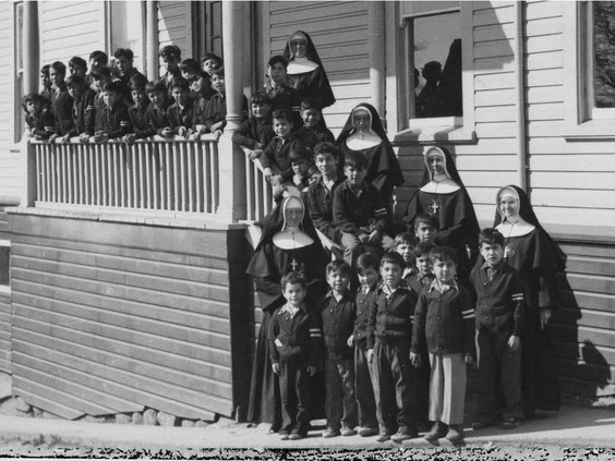 Catholic church officials with Indigenous children outside the St. Paul's Indian Residential School in North Vancouver. PHOTO BY INDIAN RESIDENTIAL SCHOOL HISTORY AND DIALOGUE CENTRE / PNG