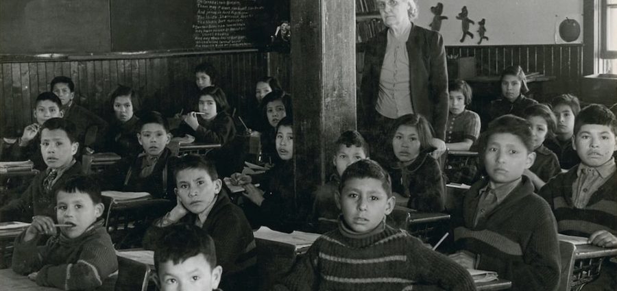 Students at their desks in in 1945 with their teacher at All Saints Indian Residential School in Lac la Ronge, Sask., where use of the Cree language was strictly forbidden. Photo: Library and Archives Canada)