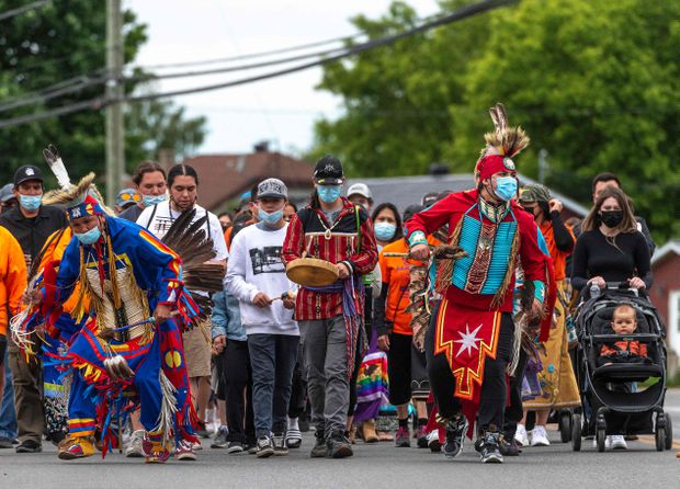 Members of the community of the Kahnawake Mohawk Territory, Quebec march through the town on May 30, 2021, to commemorate the news that a mass grave of 215 Indigenous children were found at the Kamloops Residential School in British Columbia.  Peter McCabe / Agence France-Presse