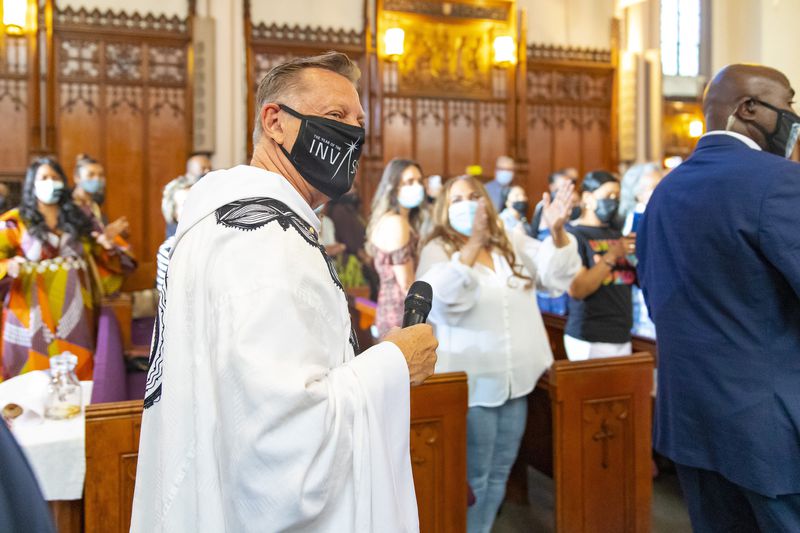 By VASHON JORDAN JR. / CHICAGO TRIBUNE The Rev. Michael Pfleger is greeted by parishioners as he enters the sanctuary at St. Sabina Church to lead the Sunday morning service on June 6, 2021. (Vashon Jordan Jr. / Chicago Tribune)