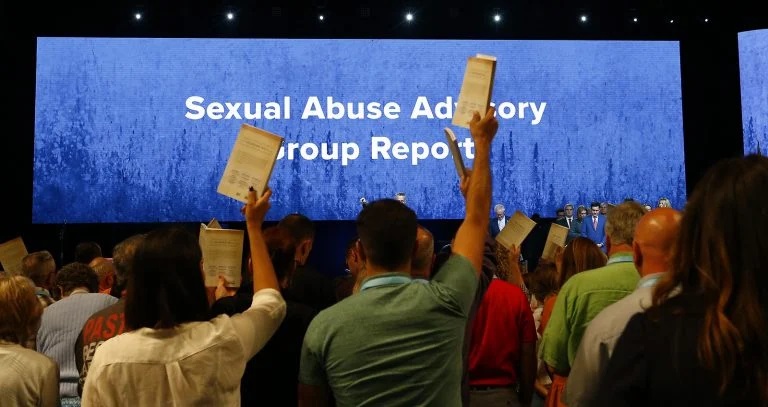 Messengers hold up an SBC abuse handbook while taking a challenge to stop sexual abuse during the annual meeting of the Southern Baptist Convention at the Birmingham-Jefferson Convention Complex, June 12, 2019, in Birmingham, Alabama. RNS photo by Butch Dill