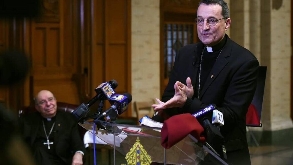 The Rev. Armando Ochoa sits to the eft in the background as Rev. Joseph V. Brennan, right, addresses the media in March 2019 after it was announced Brennan would replace Ochoa as bishop for the Diocese of Fresno. The diocese under Ochoa vowed in January 2019 to release a list of priests accused of sexual abuse. A diocese official said Wednesday, June 9, 2021 that the list will be released soon. ERIC PAUL ZAMORA FRESNO BEE FILE