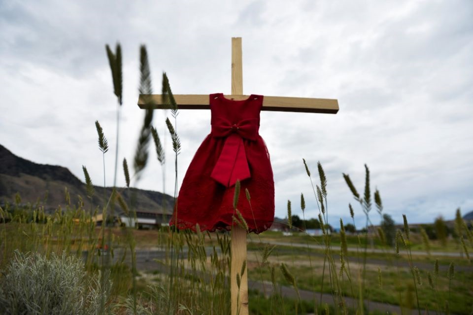 A child's red dress hangs on a cross near the grounds of the former Kamloops Indian Residential School June 6, 2021. The remains of 215 children, some as young as three years old, were found at the site in May in Kamloops, British Columbia. Pope Francis expressed his sorrow at the discovery of the remains at the school, which was run from 1890-1969 by the Missionary Oblates of Mary Immaculate. (CNS/Reuters/Jennifer Gauthier)
