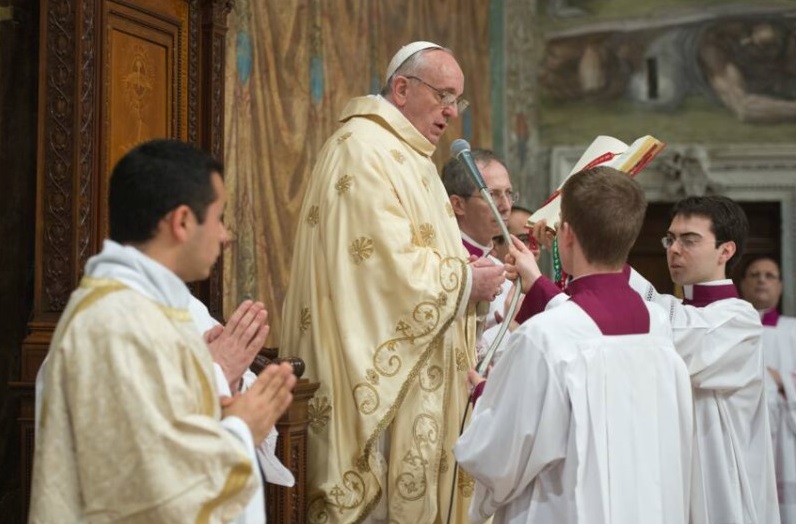 Gabriele Martinelli holds a missal for Pope Francis during the new pontiff’s first Mass in the Sistine Chapel in March 2013. (Vatican Media)
