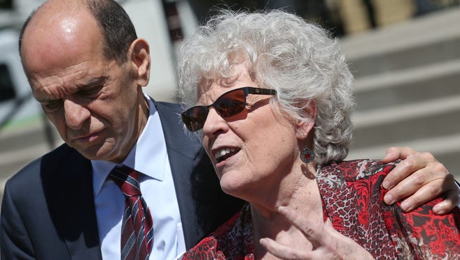 Carol DuPré, Spencerport, a victim of priest abuse as a teenager, supported by Mitchell Garabedian, Boston attorney who has represented over 3000 victims of clergy abuse, talks to the media about her coming forward outside the Diocese of Rochester on Flower City Park in Rochester Thursday, June 14, 2018.