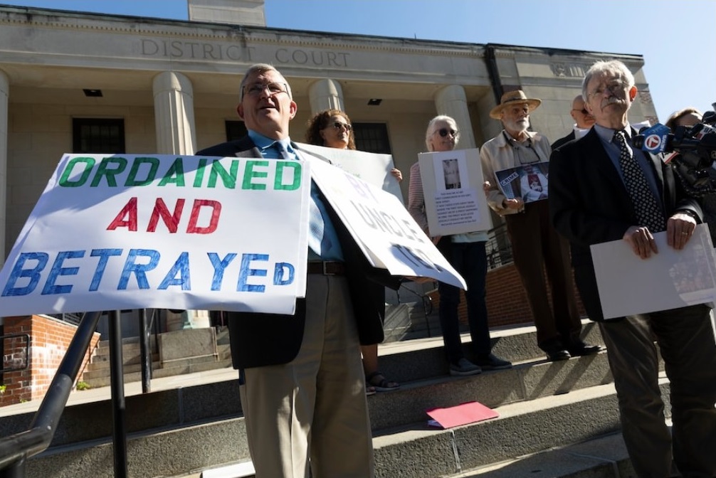 Members of BishopAccountability.org hold a news conference outside Dedham District Court following the arraignment of McCarrick. (Michael Dwyer / AP)