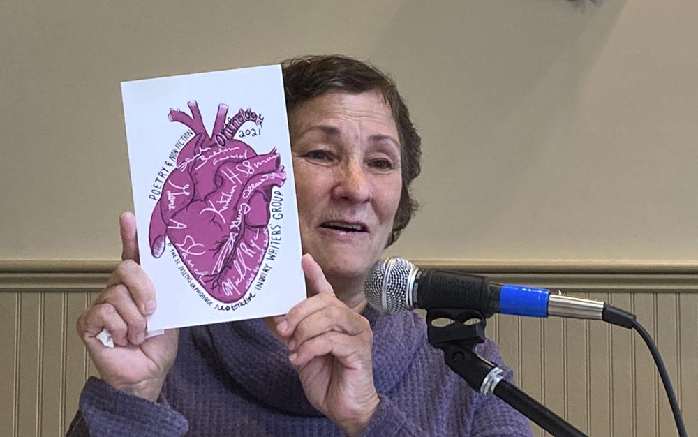 Debi Gevry-Ellsworth, of Pomfret, Conn., who lived as a child at the St. Joseph's Orphanage, holds a book of poems and essays, Thursday Sept. 16, 2021, in South Burlington, Vt. Gevry-Ellsworth attended a reunion of former residents of the closed Vermont orphanage, where former residents gathered to seek ways to recover from the abuse that many say they suffered at the orphanage. Gevry-Ellsworth said writing her portion of the book helped her move forward. (AP Photo/Wilson Ring)