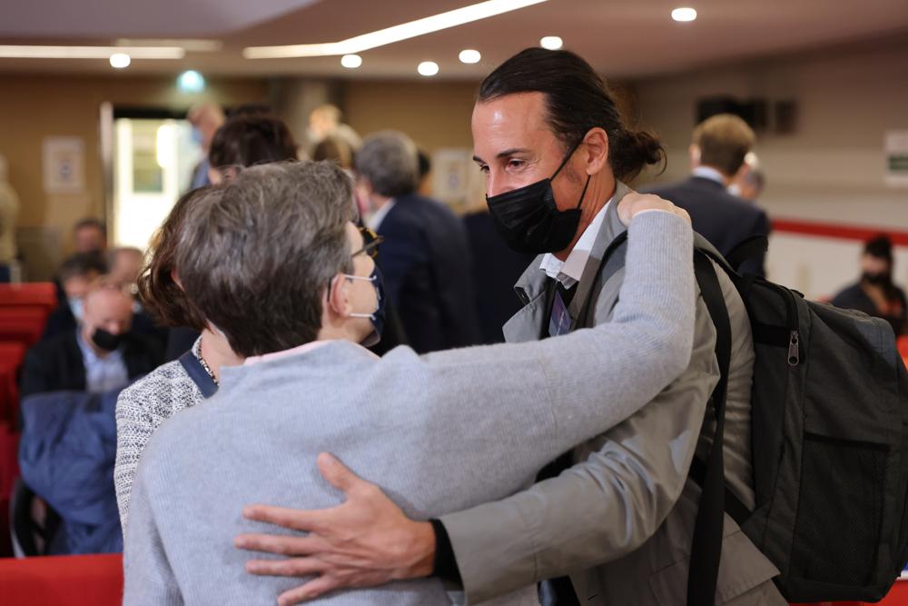 Olivier Savignac, right, one of the victims, greets an attendee during the publishing of a report by an independant commission into sexual abuse by church officials (Ciase), Tuesday, Oct. 5, 2021, in Paris. A major French report released Tuesday found that an estimated 330,000 children were victims of sex abuse within France's Catholic Church over the past 70 years, in France's first major reckoning with the devastating phenomenon. (Thomas Coex, Pool via AP)