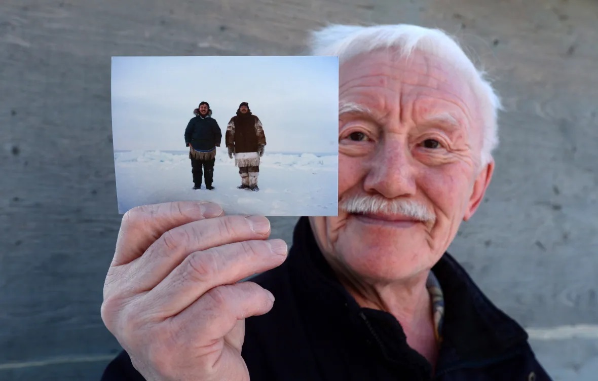 Piita Irniq holds a photograph of himself and Marius Tungilik while seal hunting 25 miles outside Rankin Inlet. Irniq promised his late friend, who named Rivoire as his abuser, he would do all he could for him and Rivoire's other alleged victims. (Sean Kilpatrick/The Canadian Press