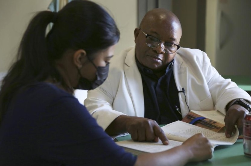 Parishioner and translator Berenice Velazquez, left, helps the Rev. Athanasius Abanulo with his Spanish before the afternoon Mass at Immaculate Conception Catholic Church in Wedowee, Ala., on Sunday, Dec. 12, 2021. After moving to the Southern U.S. one year ago, Abanulo began learning Spanish to better connect with his largely Hispanic congregations. (AP Photo / Jessie Wardarski)