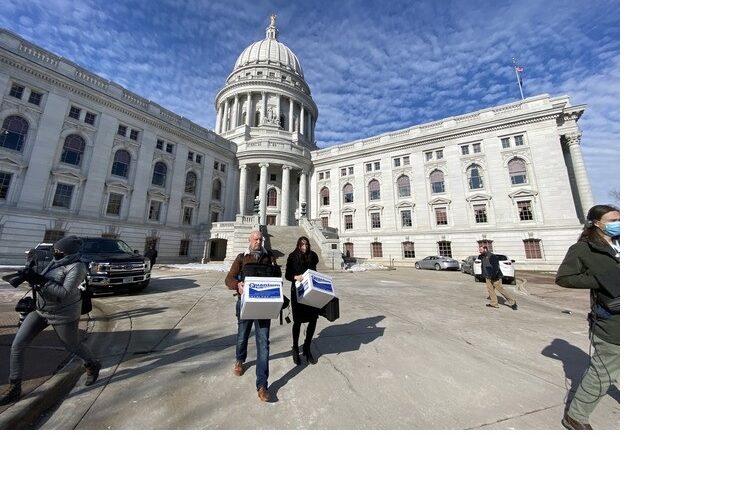 Nate's Mission director Peter Isely, left, and deputy director Sarah Pearson carry boxes of church whistleblower documents to the state attorney general's office outside the state Capitol building on Tuesday, Jan. 18, 2022. Diane Bezucha / WPR