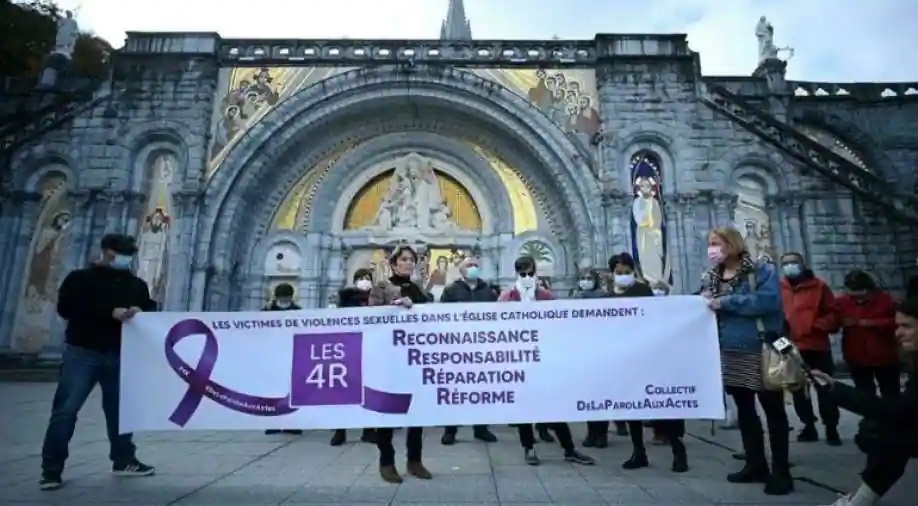 Members of the 'From words to action' collective hold a banner reading 'Victims of sexual violence in the Catholic Church demand: recognition, responsibility, reparation, reform' near the Notre-Dame-du-Rosaire basilica, in Lourdes, France Photograph:( AFP )