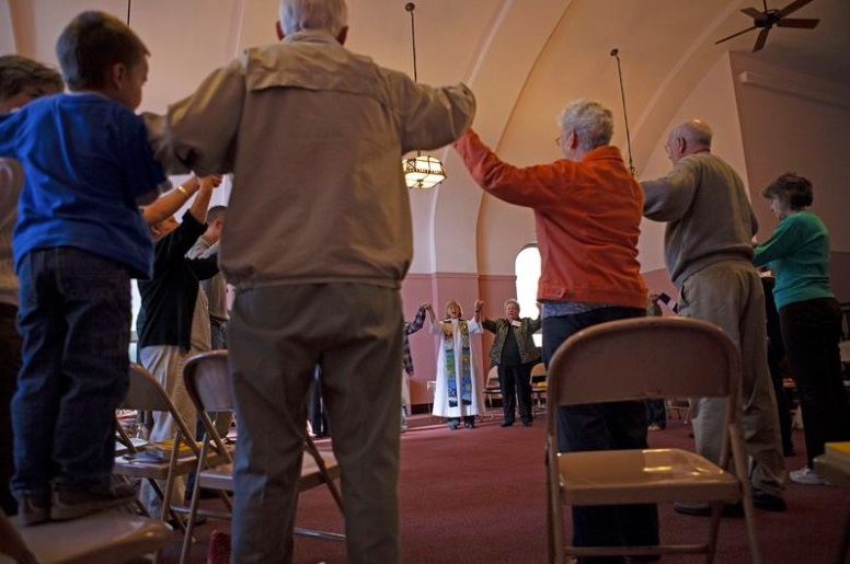 From the book "Womenpriest" by Jill Peterfeso: Womanpriest Eileen DiFranco and members of her worship community, St. Mary Magdalene in suburban Philadelphia, join hands for the Lord’s Prayer. Instead of saying, “Our Father, who art in heaven,” the gatherers say, “Our God, who art in heaven.” (Photo by Judith Levitt)