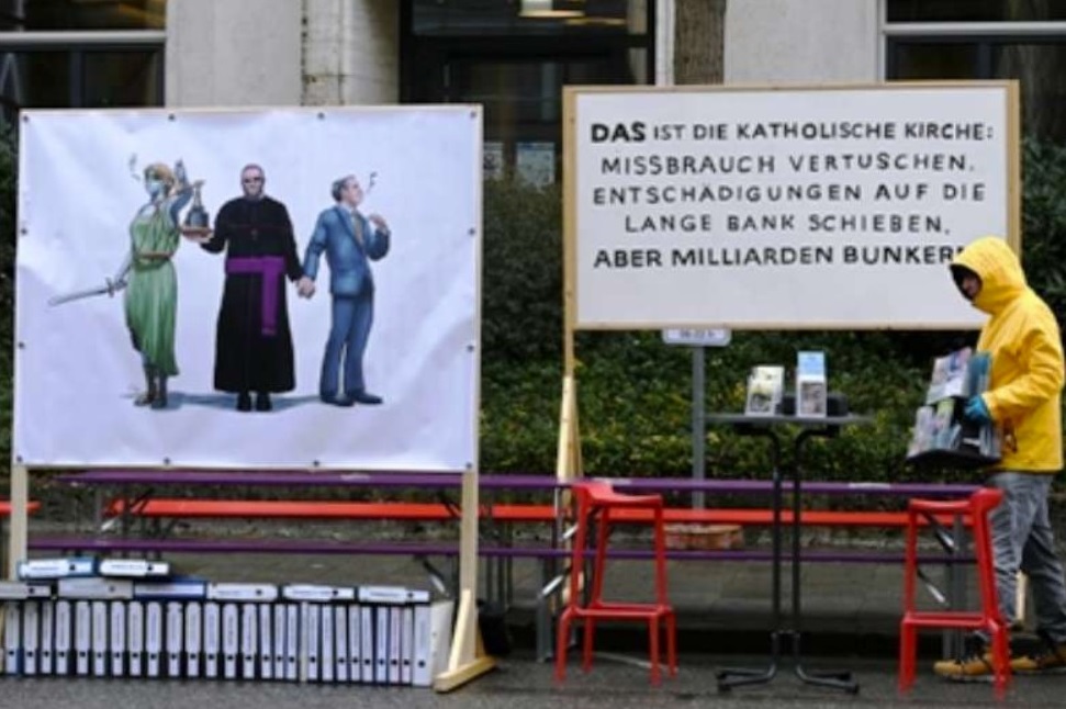 A board reads 'That's the Catholic Church: covering up abuse, putting off reparations but stashing away billions' to protest a recent report on child sex abuse in the Archdiocese of Munich-Freising in Germany. (Photo: AFP)