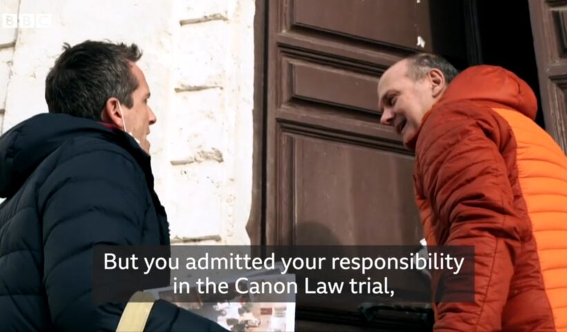 Reporter Mark Lowen interviews Rev. Gianni Bekiaris about his canonical trial. Screen image from BBC report.