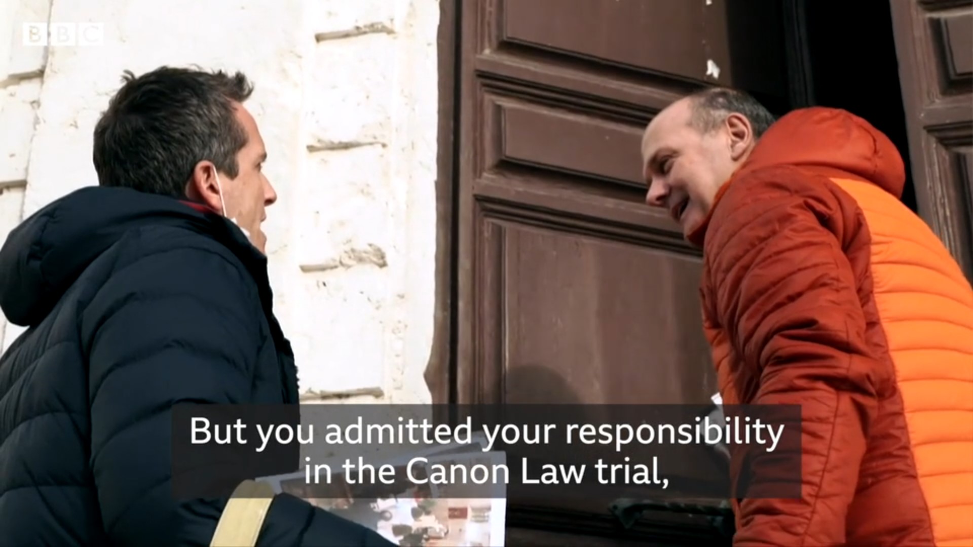 Reporter Mark Lowen interviews Rev. Gianni Bekiaris about his canonical trial. Screen image from BBC report.