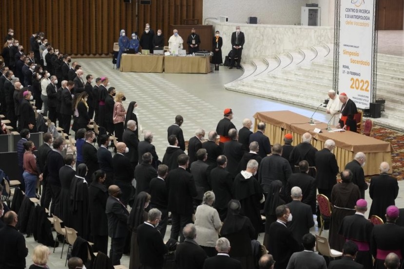 Pope Francis, standing at left at the table, and Cardinal Marc Ouellet attend the opening of a 3-day Symposium on Vocations in the Paul VI hall at the Vatican, Thursday, Feb. 17, 2022. (AP Photo / Gregorio Borgia)