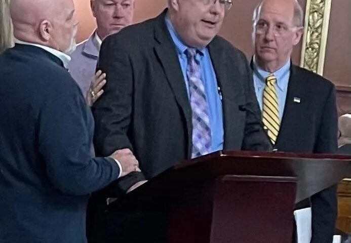 Dennis Laprade, who says his claims of childhood abuse by a Catholic priest went nowhere because of the statute of limitations, breaks down while testifying before the Rhode Island House Judiciary Committee on Thursday night. Standing to support him are, from left, Pasco Troia, Jim Scanlan and Herbert "Hub" Brennan, all victims of childhood sexual abuse.
