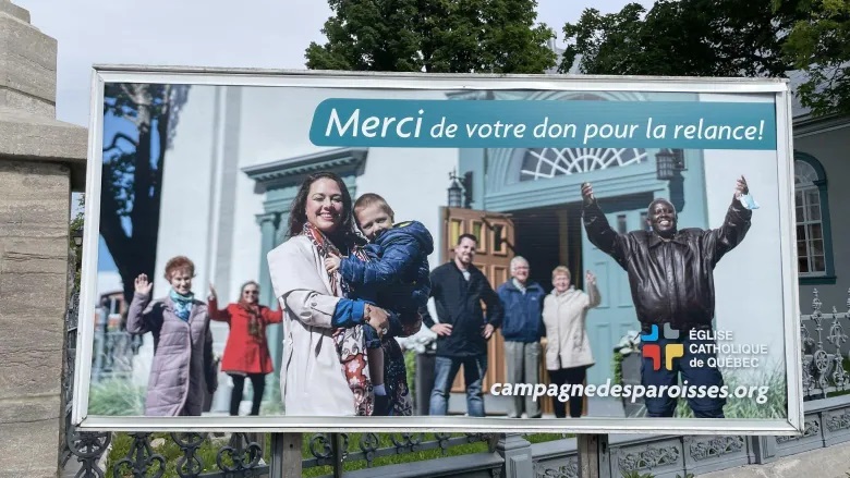 Priest Léopold Manirabarusha, pictured here on the far right of the billboard, started working for the archdiocese of Quebec in the late 1990s. (Louis-Simon Lapointe/Radio-Canada)