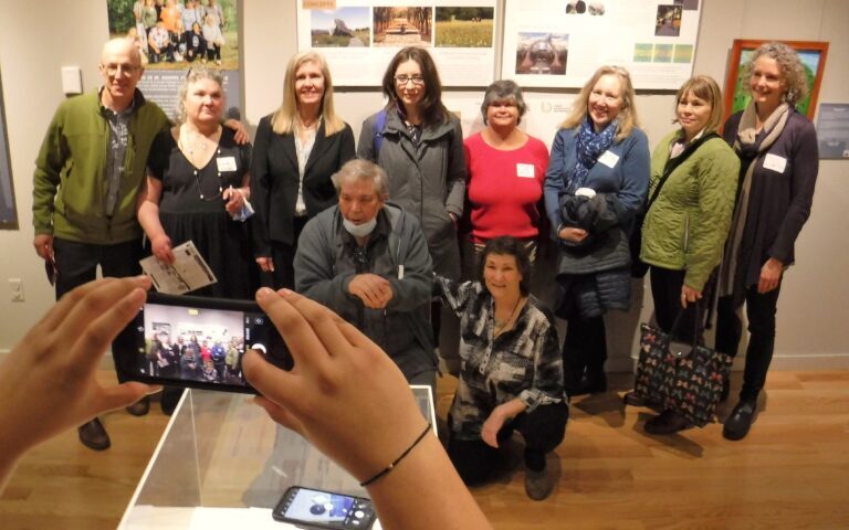 Journalist Christine Kenneally (back row center, with glasses) meets former orphanage residents and their supporters last April at the Vermont Historical Society exhibit “Voices of St. Joseph’s Orphanage.” Photo by Kevin O’Connor / VTDigger