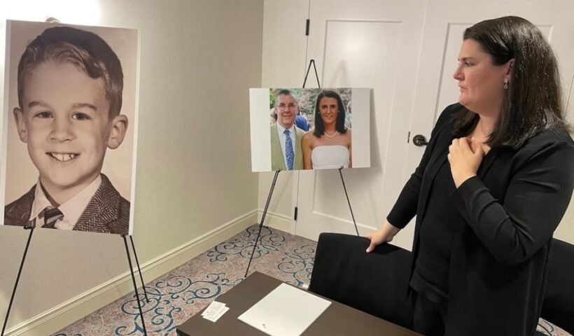 Flannery Gallagher looks at a childhood photo of her father, the late Francis X. Gallagher, Jr., at a press conference announcing a lawsuit against the Archdiocese of Baltimore and St. Mary's Seminary, on June 27, 2023, in Baltimore, Md. (Michelle Boorstein/The Washington Post)