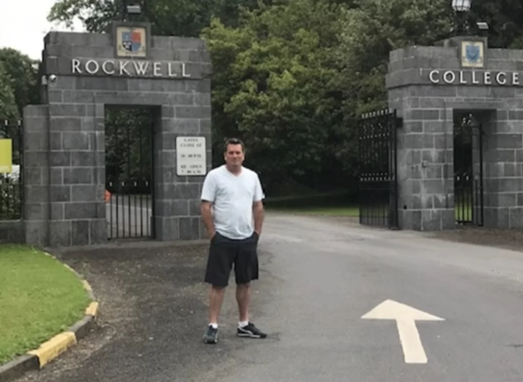 Chicago native Derek McCarthy, shown in 2018 in front of the Irish boarding school he attended years earlier, where he says he was sexually abused by Spiritan priests. – Provided