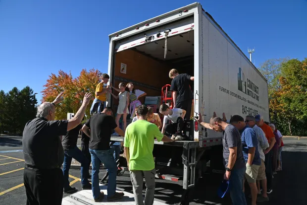 The Rev. David Ryan, left, pastor at St. Francis de Sales Catholic Parish in Lake Zurich, leads a blessing of the truck and donated contents destined for people in Tampa, Florida, who were affected by Hurricane Milton on Oct. 19, 2024. (Karie Angell Luc/Pioneer Press)