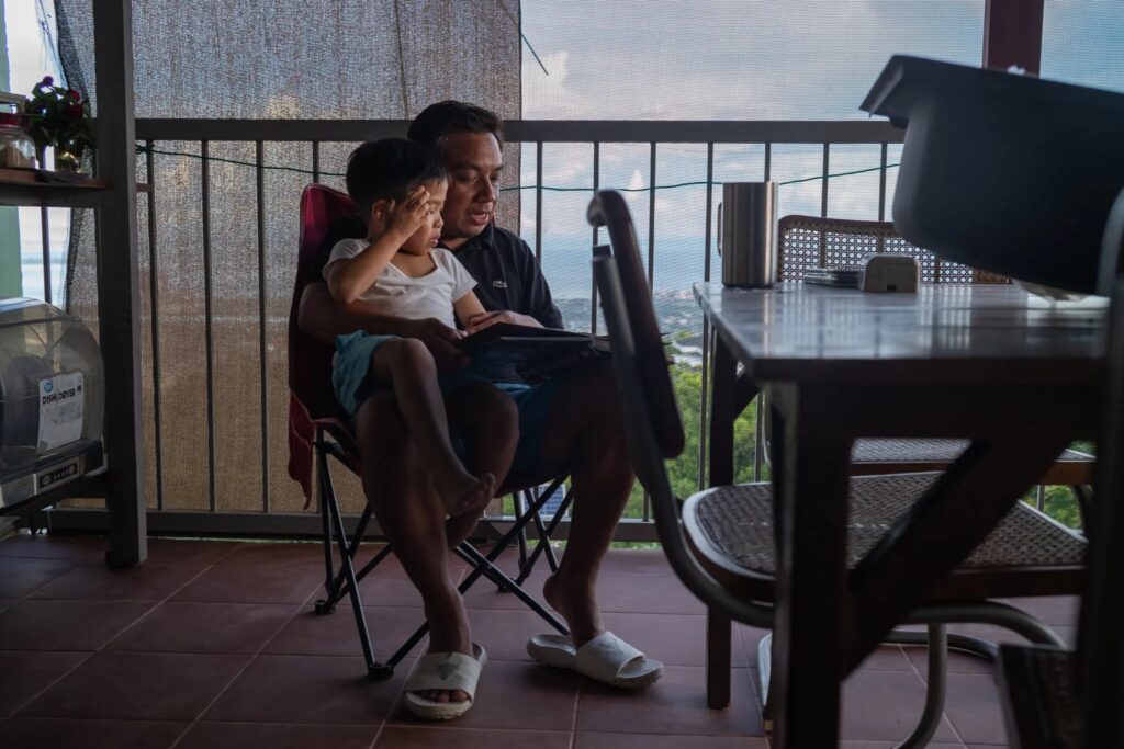 Mr. Gatchalian with his younger son. He and his wife are raising their two sons as Catholics and attend weekly Mass. (Photographs by Jes Aznar)